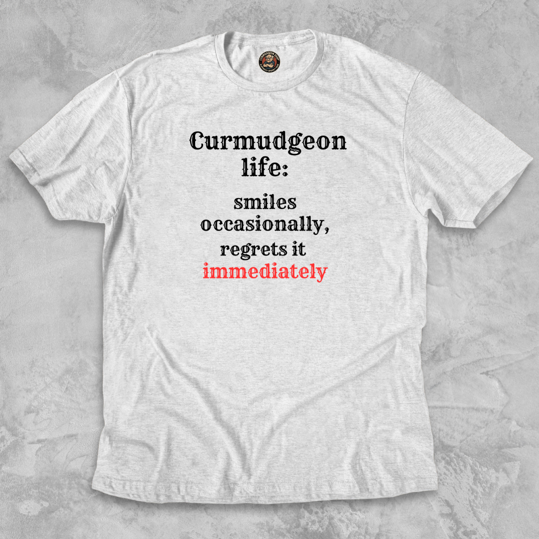 SMILES.™ – And Instantly Regrets It A tee for the man who accidentally showed emotion.