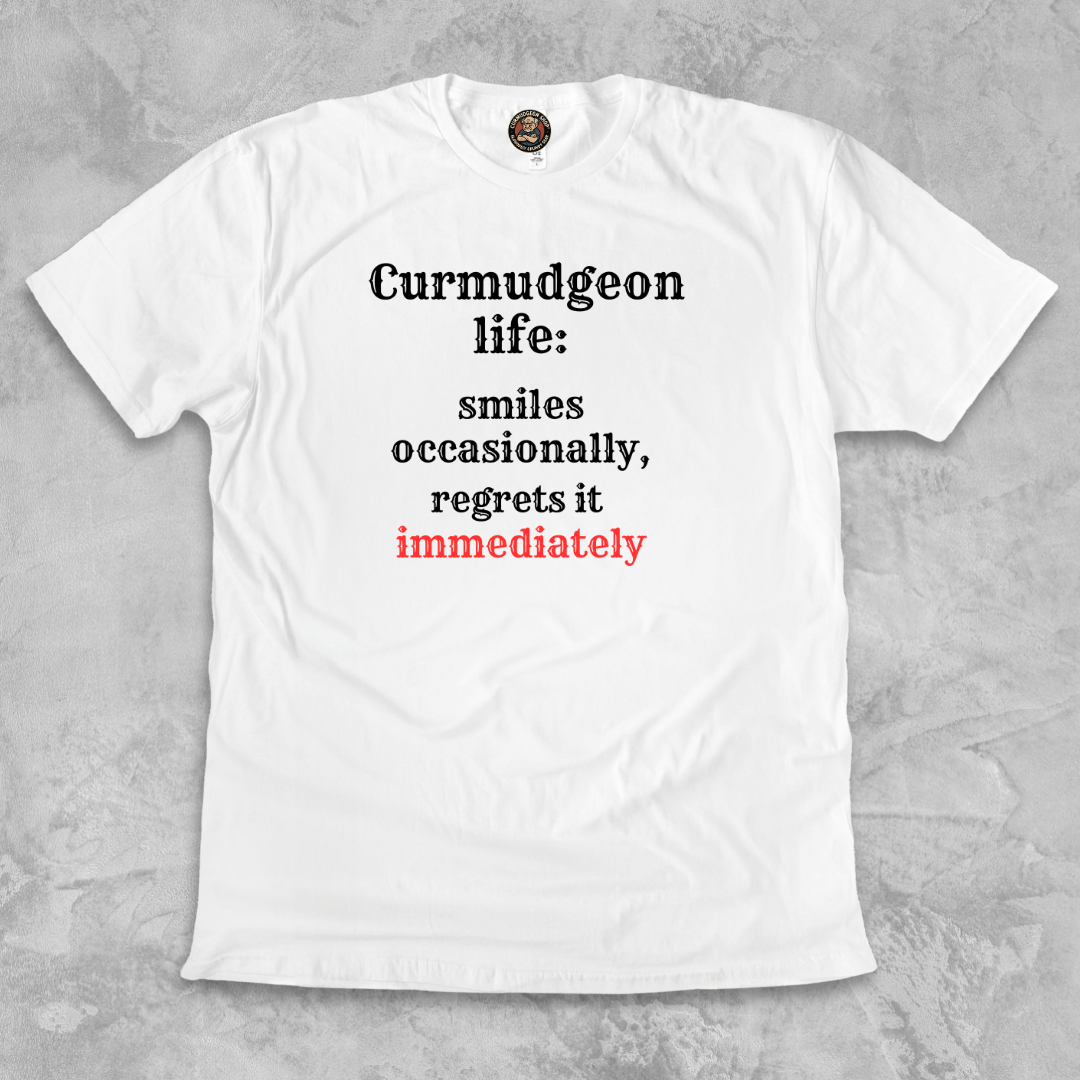 SMILES.™ – And Instantly Regrets It A tee for the man who accidentally showed emotion.