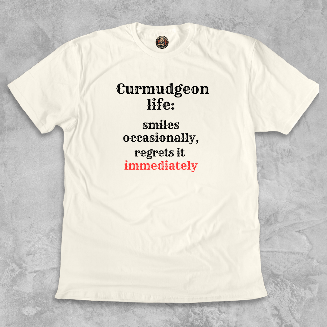 SMILES.™ – And Instantly Regrets It A tee for the man who accidentally showed emotion.